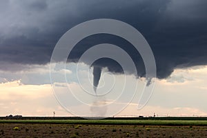 Tornado touching down in a field