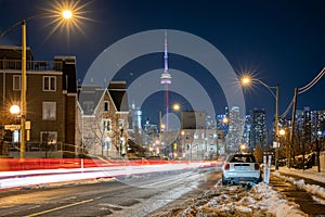 Car light trails in West Queen West leading towards the Toronto skyline and CN Tower - Winter snow