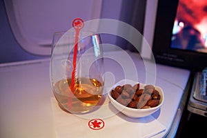 TORONTO, CANADA - JAN 28th, 2017: Air Canada Business class in a passenger plane. A glass of whisky and some warm nuts