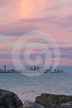 Toronto city skyline and CN Tower with colourful pink clouds in the background.