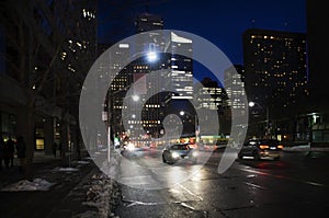 Toronto downtown street view with cars headlamps reflection on wet asphalt