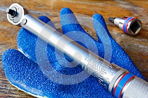 Torque wrench and work glove on the table in workshop