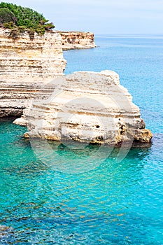 Torre Sant Andrea beach with its soft calcareous rocks and cliffs, sea stacks, small coves and the jagged coast landscape. Crystal