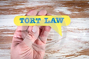 Tort Law. Yellow speech bubble in a man& x27;s hand