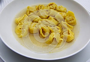 Tortellini in brodo in broth in a white plate, italian emilia-romagna pasta