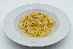 Tortellini in brodo tortellini in broth in a white dish. Traditional italian cuisine. photo