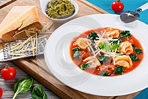 Tortellini soup with italian sausages, spinach, tomato, parmesan cheese , pesto-sauce