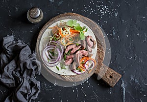 Tortilla with beef steak, marinated carrots and cabbage. Delicious lunch snack. On a dark background