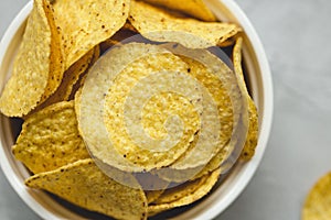 Tortilla corn chips in bowl an a gray background