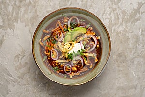 Tortilla soup with avocado and cheese. Mexican food