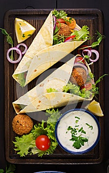 Tortilla wrap with falafel and fresh salad. Vegan tacos.