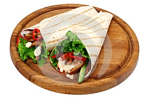 Tortilla wrap with fried chicken meat and vegetables on wooden board isolated on white background