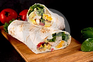 Tortilla wrapped with fried chicken meat, vegetables and corn