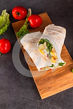 Tortilla wrapped with fried chicken meat, vegetables and corn
