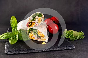 Tortilla wrapped with fried chicken meat, vegetables and corn