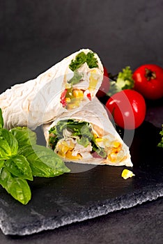 Tortilla wrapped with fried chicken meat, vegetables and corn