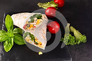 Tortilla wrapped with fried chicken meat, vegetables and corn