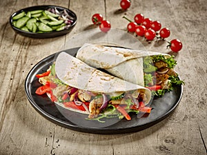 Tortilla wraps with fried chicken meat and vegetables