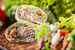 Tortilla wraps with meat, vegetables, mayonnaise with a salad on the side