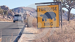 Tortoise or turtle crossing yellow road sign, California USA. Wild animal xing.