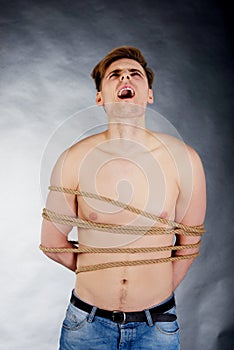 Tortured man tied with a rope.