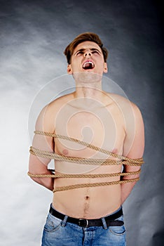 Tortured man tied with a rope. photo