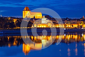 Torun old town at night reflected in Vistula river photo