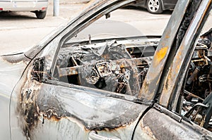Total damage on new expensive burned car in fire on the parking lot, selective focus