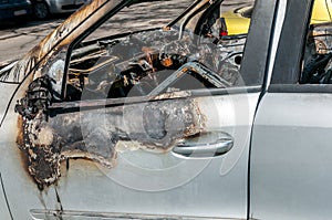 Total damage on new expensive burned car in fire on the parking lot, selective focus close up