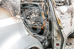 Total damage on new expensive burned car in fire on the parking lot, selective focus close up