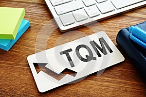 Total Quality Management TQM concept. Report on a desk
