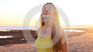 Total relax. Free happy woman enjoying breathing at sunset on the beach. Young woman relaxing in summer sunset sky outdoor. People