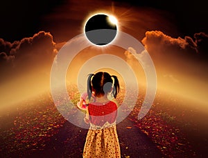 Total solar eclipse glowing above child on pathway with night sk