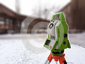 Total station at work on a blurred industrial background