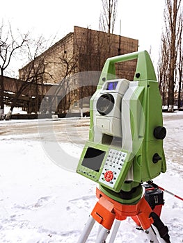 Total station at work on a blurred industrial background