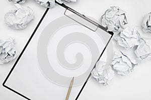 Total white monochromatic stationery flat lay. Notepad, white pencil and crumpled paper balls on white background