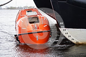 Totally Enclosed Lifeboat floating near big vessel