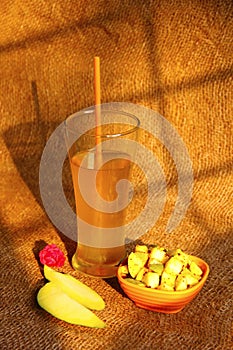 Bowl of sliced totapuri mango and glass with mango juice photo