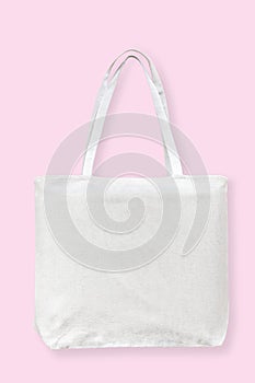 Tote bag canvas white cotton fabric cloth for eco shoulder shopping sack mockup blank template isolated on pastel pink background