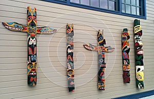 Totem poles on a wall outside Ye Olde Curiosity Shop