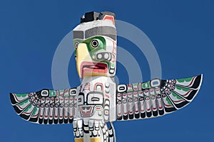 A totem wood pole in the blue cloudy background