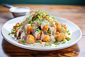 tots with sour cream and green onions topping