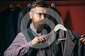 In touch with clients. Bearded man tailor sewing jacket. retro modern tailoring workshop. sewing mechanization. suit