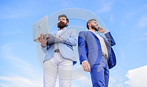 Always in touch. Men well groomed businessman holds laptop partner speak phone blue sky background. Communicating skill