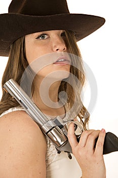 Tough cowgirl holding large pistol hair in face glaring