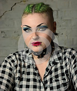 Tough looking punk girl. Facial piercings & green hair, spiked collar. photo