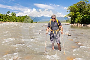 Tough man crossing jungle river stream Quincemil, Peru travel.