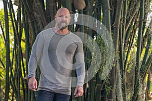 Tough man posing in a bamboo garden