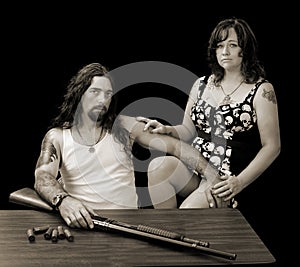 Tough man with tough woman and a shotgun with shellson