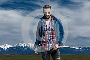 Tough man while wearing jeans jacket and sunglasses